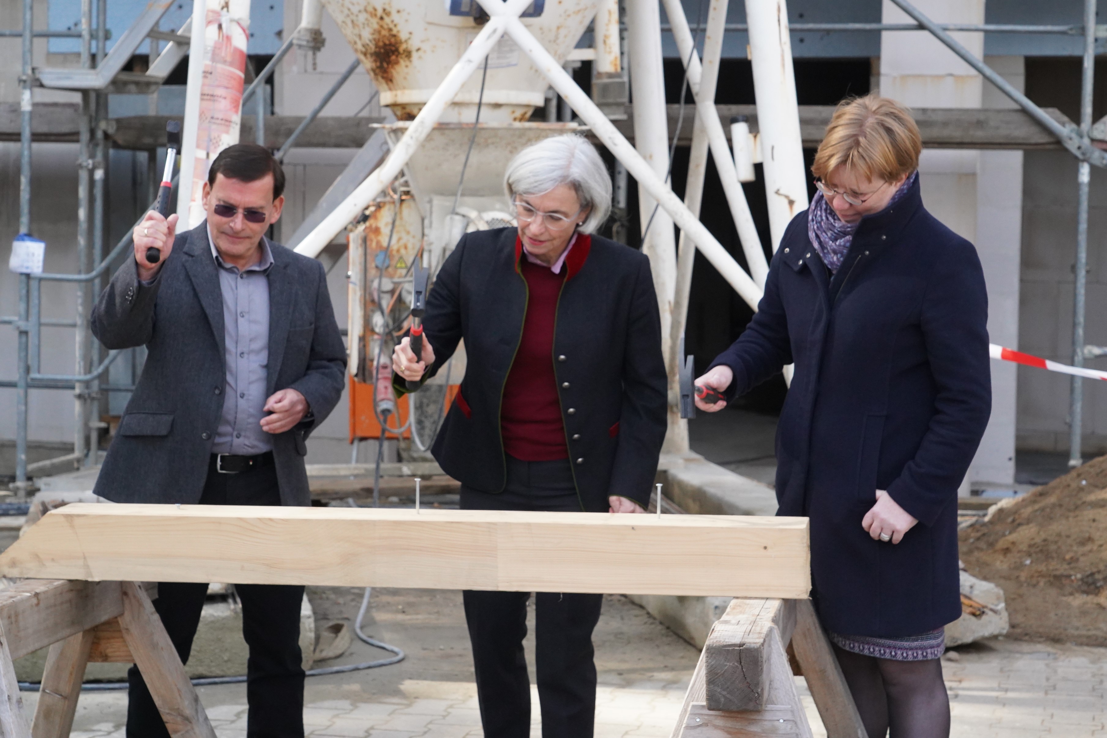 Die letzten Nägel in den Sparren getrieben: Stefan Lochner, Andrea Wagner-Pinggéra und Katja Möhlhenrich-Krüger beim Richtfest der künftigen Seniorenwohnanlage in Werneuchen.