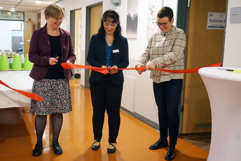 Katja Möhlhenrich-Krüger, Leiterin der Altenhilfe, Jeannette Liepe, Praxisleiterin und Jeannette Pella, Leiterin Bereich Teilhabe, durchschneiden das rote Band.